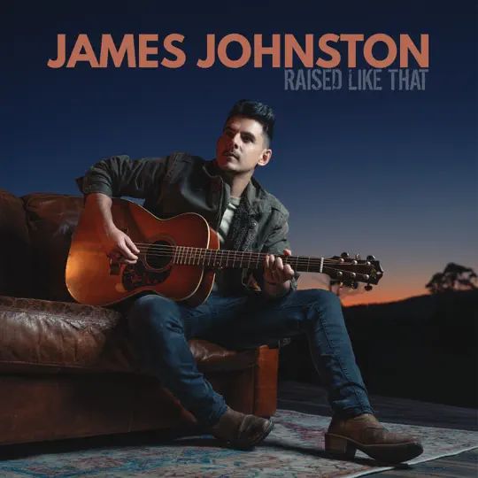 A man sitting on a couch playing a guitar