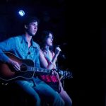 A man and woman playing guitar