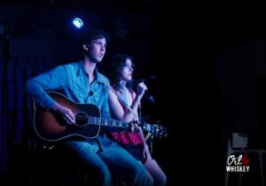 A man and woman playing guitar